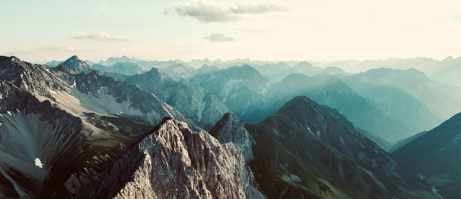 Panoramablick auf die Bergkulisse in Tirol mit alpinen Gipfeln, Tälern und Abendlicht